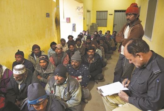 A policeman, right, takes details from an arrested Indian fisherman at a police station in Karachi yesterday.