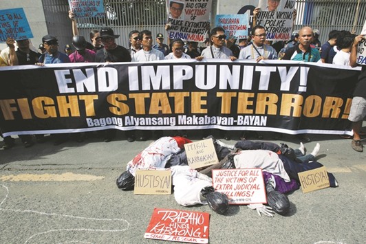Effigies of corpses are seen with placards as activists protest against the extra-judicial killings in the country involving the war on drugs of President Rodrigo Duterte, during a rally outside the Philippine National Police (PNP) headquarters in Quezon City yesterday.