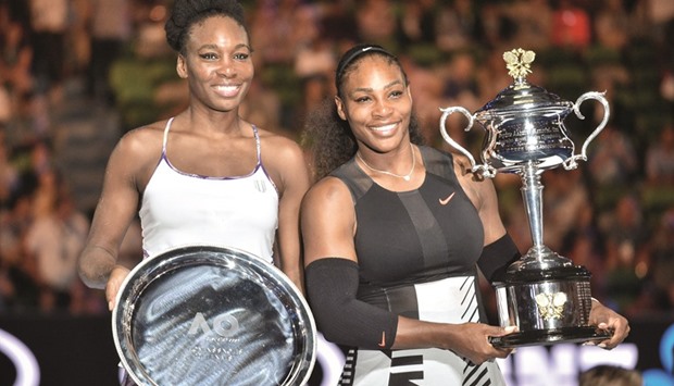 Serena Williams (right) and elder sister Venus with their Australian Open winner and runner-up trophies. (AFP)