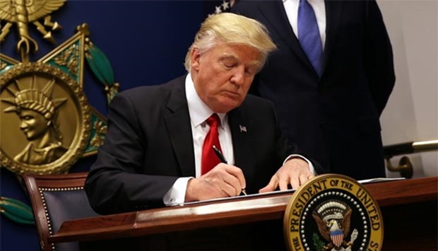President Donald Trump signs an executive order to impose tighter vetting of travellers entering the United States, at the Pentagon in Washington on Friday.