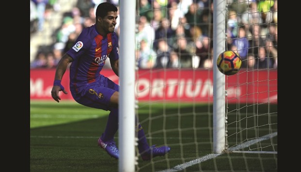 Barcelonau2019s Luis Suarez eyes the ball as he scores a goal during the La Liga match against Real Betis yesterday. (AFP)