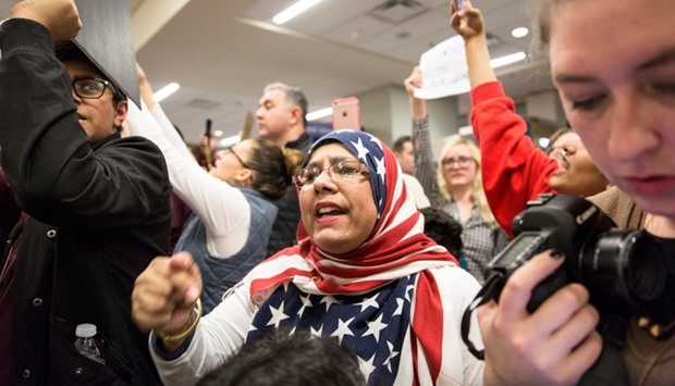 A woman in an American flag hijab chants with other protesters against the travel ban imposed by US President Donald Trump's executive order, at Dallas/Fort Worth International Airport in Dallas, Texas.