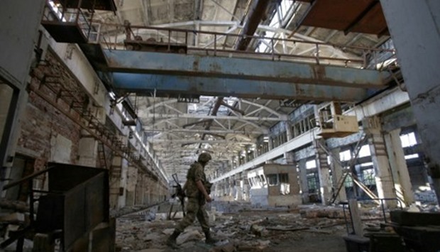 A Ukrainian soldier walks through a shell-damaged factory during a battle with pro-Russian separatists at Avdiyivka, in Ukraine's Donetsk Oblast. File picture on June 25, 2016.  AFP.