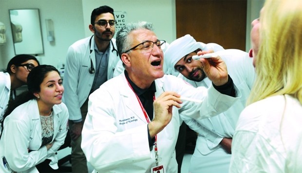 Dr. Basim Uthman shows WCM-Q students how to conduct a basic health check as WCM-Qu2019s new curriculum integrates scientific theory, physicianship skills and patient care more than ever before.