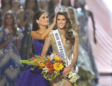 Miss Universe contestant Iris Mittenaere (right) of France is crowned the new 2017 winner by former Miss Universe Pia Wurtzbach of the Philippines during the Miss Universe pageant at the Mall of Asia Arena in Manila yesterday.