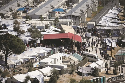 This file picture taken last year shows migrants lining up for food distribution at the Moria migrant camp in Lesbos.