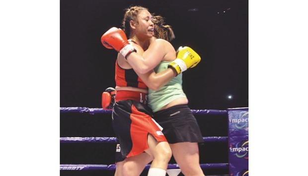 Indiau2019s Laishram Sarita Devi (L) fights against Hungaryu2019s Zsofia Bedo during their IBC Pro Boxing match at the Khuman Lampak Indoor Stadium in Imphal. (AFP)