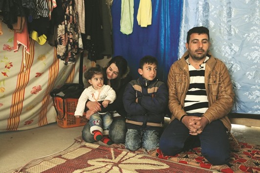 Khudeeda Naif and his family, from a minority Yazidi community, sit inside a tent at a refugee camp near Duhok, Iraq yesterday.