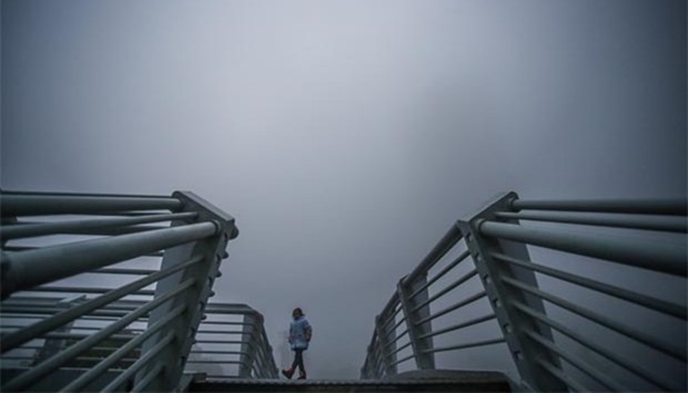 A girl walks in heavy smog on a bridge in Hefei, Anhui province on Tuesday.