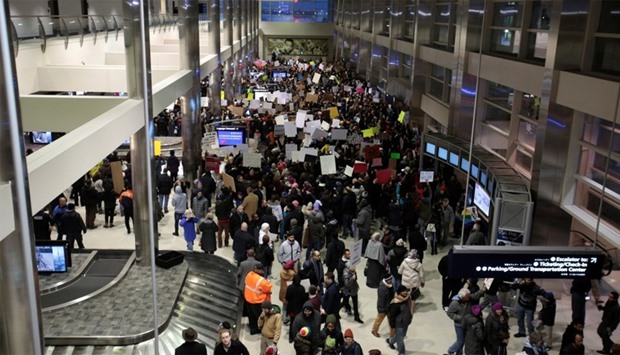 Protestors fill the baggage claim area during a rally against a temporary travel ban