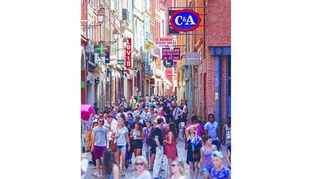 Pedestrians pass retail stores in Toulouse, France. Household spending and corporate investment spurred the fourth-quarter expansion in France, allowing domestic demand to contribute 0.6 percentage point to growth, Insee said.
