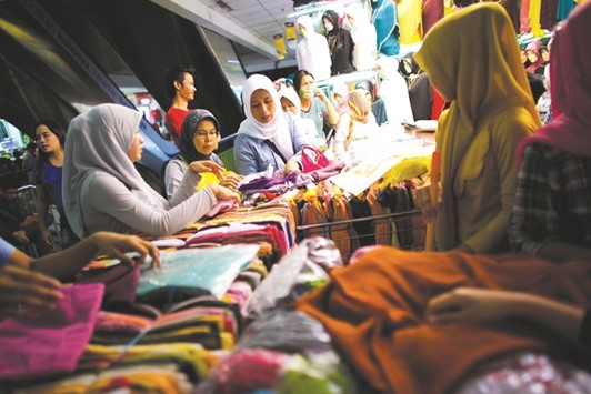 Indonesian women shops at a clothing store in a large textile market in Jakarta (file). Indonesiau2019s planned halal economic zone in the capital Jakarta could include Islamic banks and financial institutions, as well as halal restaurants, hotels, malls, halal fashion boutiques and halal entertainment.