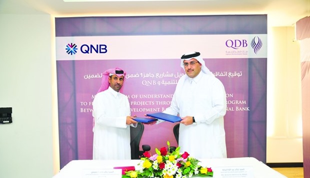 Al-Mana (right) exchange documents with al-Nuaimi as part of the MoU signed among QDB, QNB and QIB, facilitating access to finance up to 70% of the project value with a maximum limit of up to QR15mn per project to u2018Jahiz Iu2019 participants