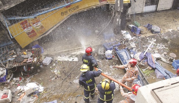 Firefighters spray water at a burning market in Dhaka yesterday.