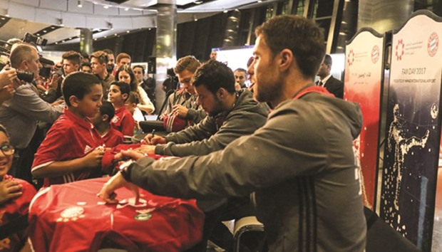 Bayern Munich players David Alaba, Xabi Alonso, Juan Bernat and Joshua Kimmich sign autographs for fans on their arrival at the Hamad International Airport in Doha yesterday. (Twitter/Bayern Munich)
