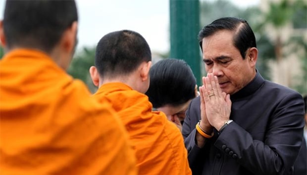 Thailand's Prime Minister Prayuth Chan-ocha offers alms to Buddhist monks before a weekly cabinet meeting at Government House in Bangkok on Wednesday.