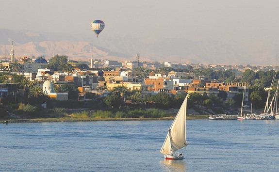 A balloon is seen above the Nile River as boats wait for tourists in the port city of Luxor, south of Cairo. Egypt has contended with a shortage of dollars that has made its black market the primary source of hard currency since a 2011 uprising scared off foreign investors and tourists, key sources of dollars.