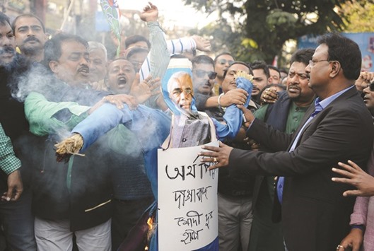 Activists of the Trinamool Congress shout slogans as they burn an effigy of Prime Minister Narendra Modi during a protest meeting in Siliguri yesterday.