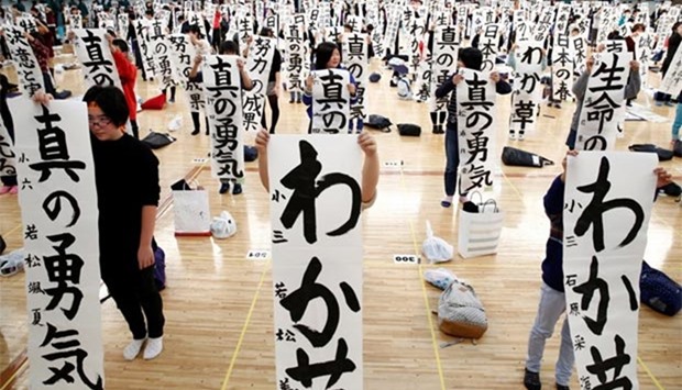 Participants show off their writings at a New Year calligraphy contest in Tokyo on Thursday.