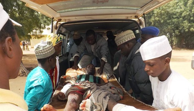 A man injured is taken to an ambulance in Potiskum, Nigeria, after a 10 year old girl suicide bomber blew herself up in a busy market. 23 February, 2015 file picture.