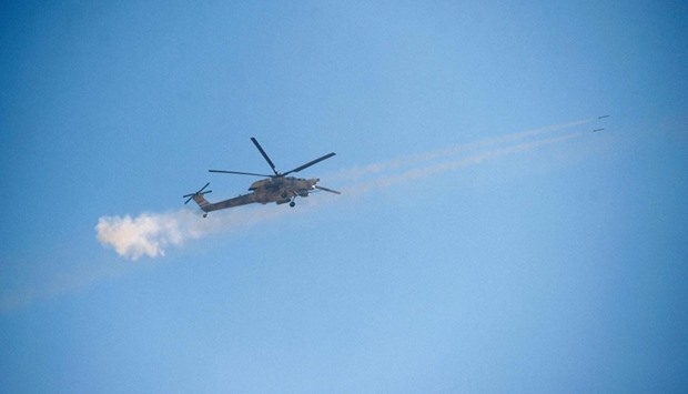 An Iraqi army helicopter fires towards Islamic State (IS) group target, as it flies over the western edge of Al-Intisar neighbourhood in southeastern Mosul.