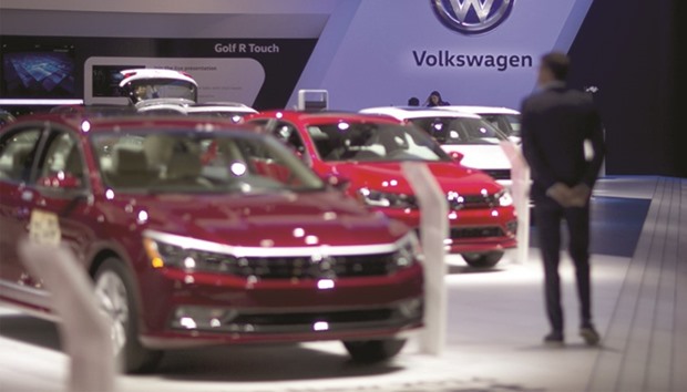 A Volkswagen signage is seen above vehicles at the companyu2019s booth during the 2016 North American International Auto Show (NAIAS) in Detroit, Michigan. Volkswagen has agreed to spend as much as $17.5bn in the United States to resolve claims from owners and federal and state regulators over polluting diesel vehicles.