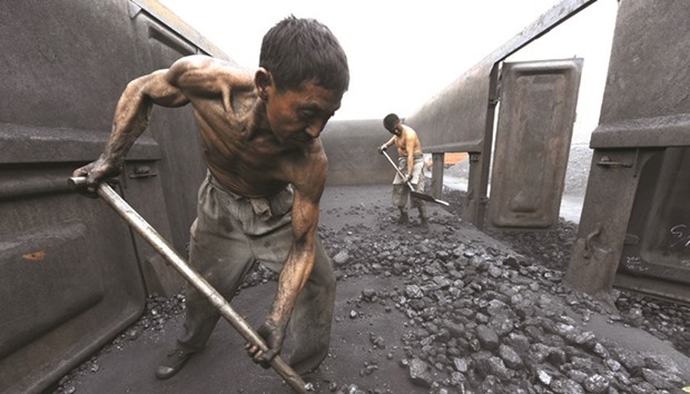 Workers unload coal at a storage site along a railway station in Hefei, Anhui province. Miners including two of the nationu2019s largest, China Coal and Shenhua, have signed deals with utilities, the top consumers of thermal coal, for only about 40% of their 2017 output at discounts to the spot market, according to four sources familiar with the contracts.