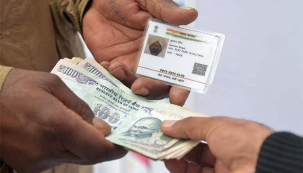 An Indian withdraws money from his bank account with an Aadhaar or Unique Identification Card during a Digi Dhan Mela, held to promote digital payment, in Amritsar on Friday.