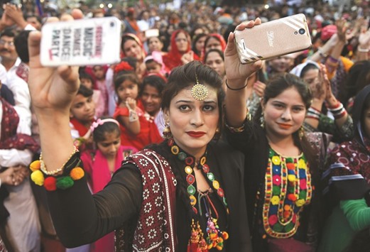 Young Sindhi women pose for a u2018selfieu2019 as they attend a Sindh Cultural festival in Karachi.