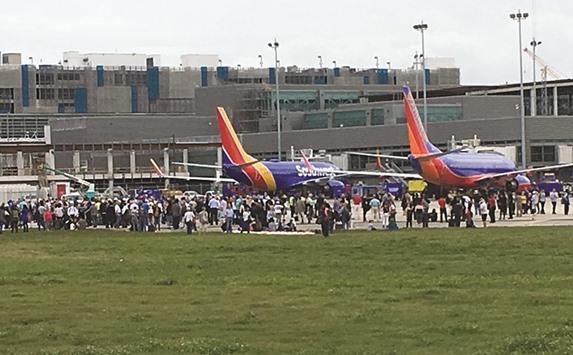 Travellers are evacuated out of the terminal and onto the tarmac after airport shooting at Fort Lauderdale-Hollywood International Airport in Florida yesterday.