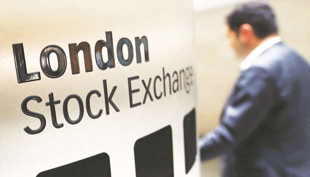 A visitor passes a sign inside the London Stock Exchange Group (LSE) headquarters. Londonu2019s FTSE 100 was up at 7,210.05 points at close yesterday.