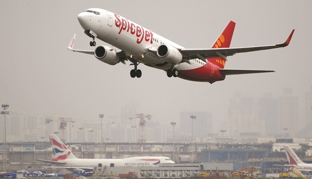 A SpiceJet aircraft takes off as a British Airways plane sits on the tarmac at the international airport in Mumbai. The Indian budget airline is poised to order at least 92 Boeing 737 jetliners as the carrier plots rapid expansion in the worldu2019s fastest growing aerospace market.