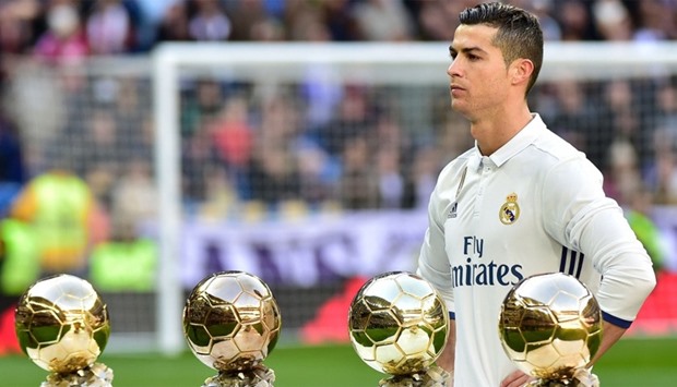 Real Madrid's Portuguese forward Cristiano Ronaldo poses with his four Ballon d'Or France Football trophies
