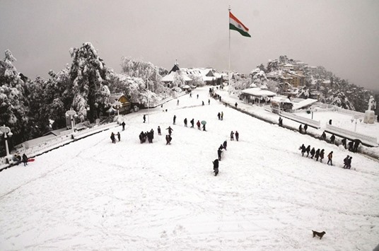 Tourists stroll in the snow-blanketed Shimla in Himachal Pradesh yesterday.