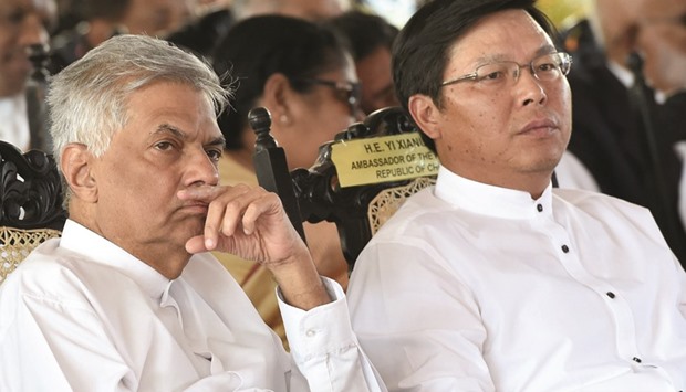 Sri Lankan Prime Minister Ranil Wickremesinghe, left, and Chinese ambassador Yi Xianliang look on during the opening ceremony of an industrial zone project in the southern port city of Hambantota yesterday.