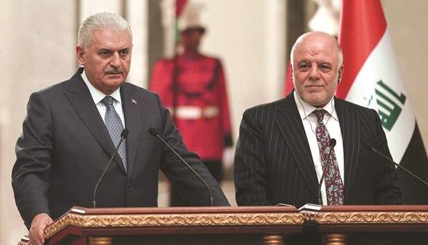 This handout photo provided by the Turkish Prime Ministeru2019s Press Office shows Turkish Prime Minister Binali Yildirim (left) and Iraqi Prime Minister Haider al-Abadi holding a joint press conference after the  High Level Strategic Co-operation Council meeting at the governmental palace in Baghdad yesterday.