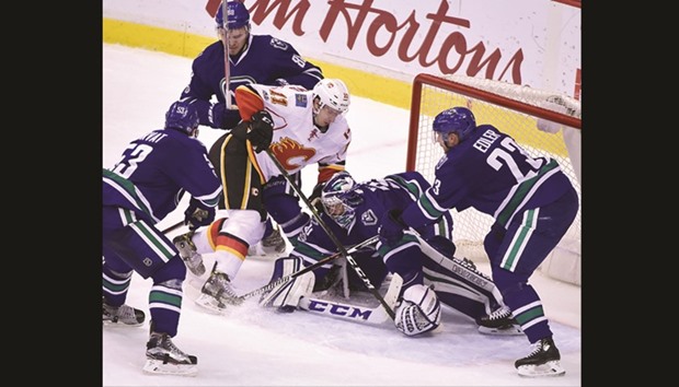 Vancouver Canucks goaltender Ryan Miller (30) stops the puck against Calgary Flames Mikael Backlund during the third period. (AFP)