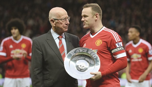 This file photo taken on December 19, 2015 shows Manchester Unitedu2019s English striker Wayne Rooney (R) receiving an award from former Manchester United player Sir Bobby Charlton (R) before playing in his 500th game for his club in the English Premier League match against Norwich City at Old Trafford. (AFP)