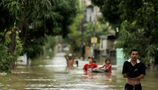 People walk in a flooded street at Muang district in Nakhon Si Thammarat province, southern Thailand. Reuters
