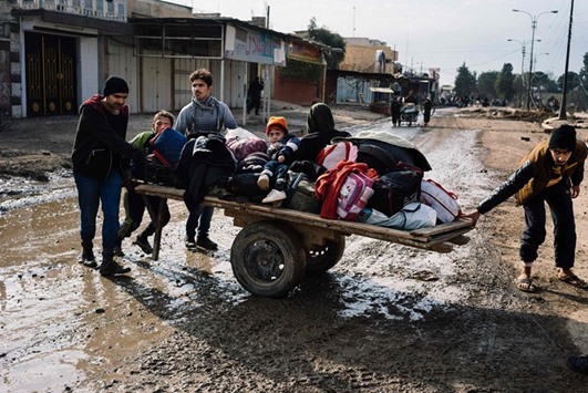 Iraqis pull a cart with their belongings in a street in Mosulu2019s al-Zahraa neighbourhood yesterday, as they flee with other civilians during an ongoing military operation against Islamic State group militants.