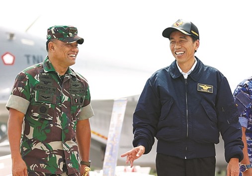 Indonesia President Joko Widodo (right) talks with military Chief Gatot Nurmantyo as they walk past fighter jets during a military exercise in Natuna Island, Indonesia.