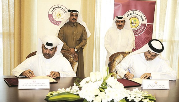 Khalid Sadiq al-Hashmi and Dr Judge Hassan Mohamed al-Muhannadi sign the MoU, in the presence of HE the Minister of Transport and Communications Jassim Seif Ahmed al-Sulaiti and Masoud Mohamed al-Amiri.