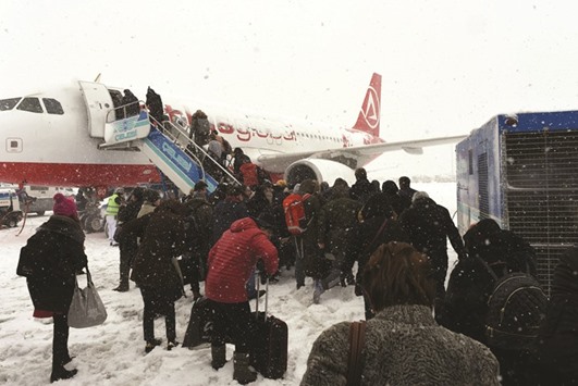 People board a plane during snowfall yesterday at Ataturk international airport in Istanbul.