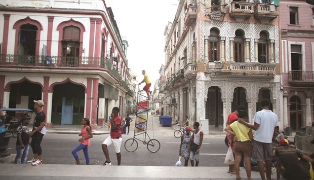 Felix Guirola, 52, rides a homemade bike with an advertising banner in Havana, Cuba.