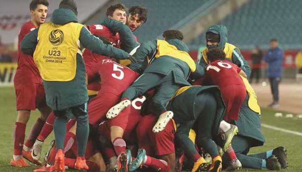 Qatar players celebrate their  win. At bottom, coach Sanchez reacts during the match.