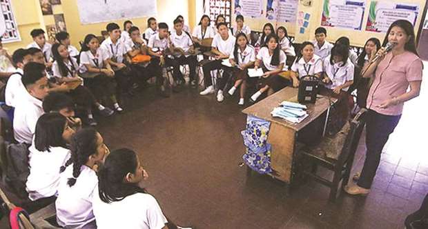 Maybeth Ferrer, a teacher conducts a class at Araullo High School on UN Avenue in Manila yesterday.