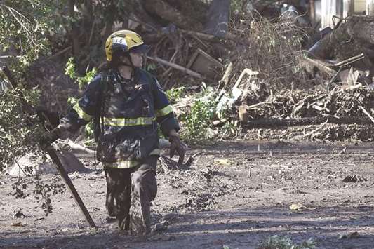 A member of the Orange County Fire Department Urban Search and Rescue team looks for survivors amid the mud, debris and destruction caused by a massive mudflow in Montecito, California.