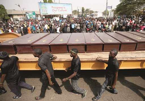 Men march along the truck carrying coffins of people killed by the Fulani herdsmen in Makurdi yesterday.