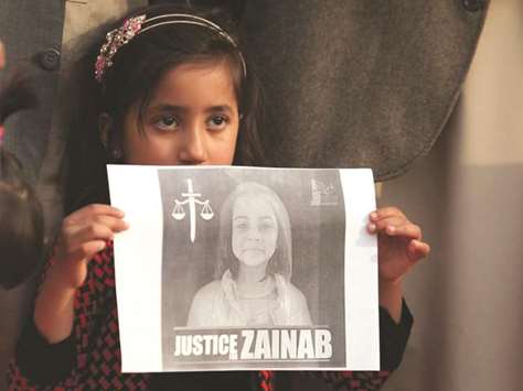 A girl holds up a picture of Zainab Ansari during a protest yesterday in Islamabad.