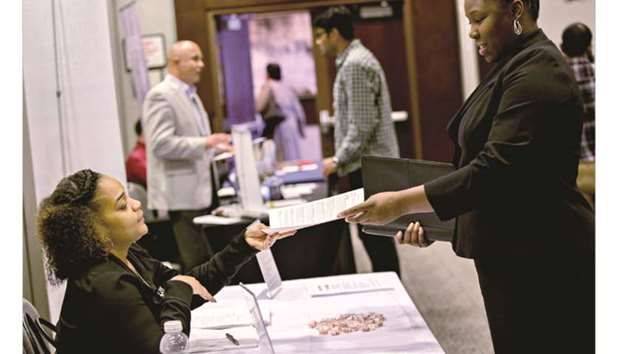 A job seeker hands her resume to a representative during a career fair in Chicago. Data yesterday showed initial claims for unemployment benefits in the US increasing for the fourth straight week to more than a three-month high.